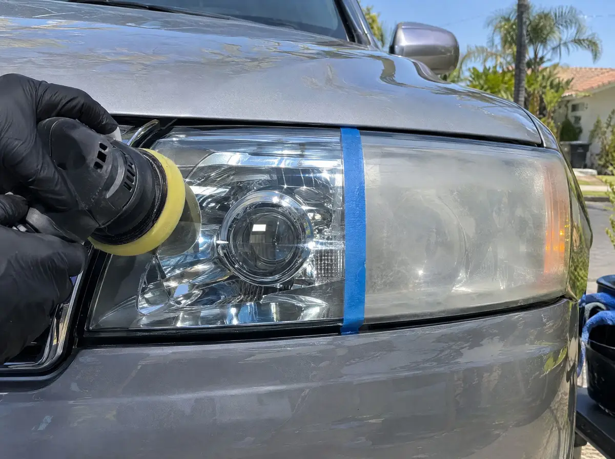 Polisher on a headlight, the polished half clear and the other half still cloudy