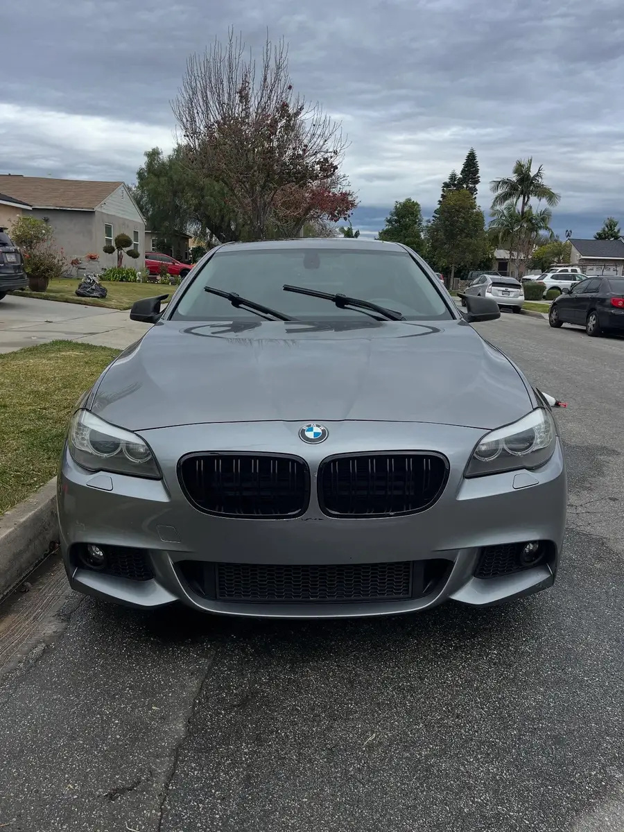 Grey BMW 528i head-on after a detail, parked at the curb on a residential street