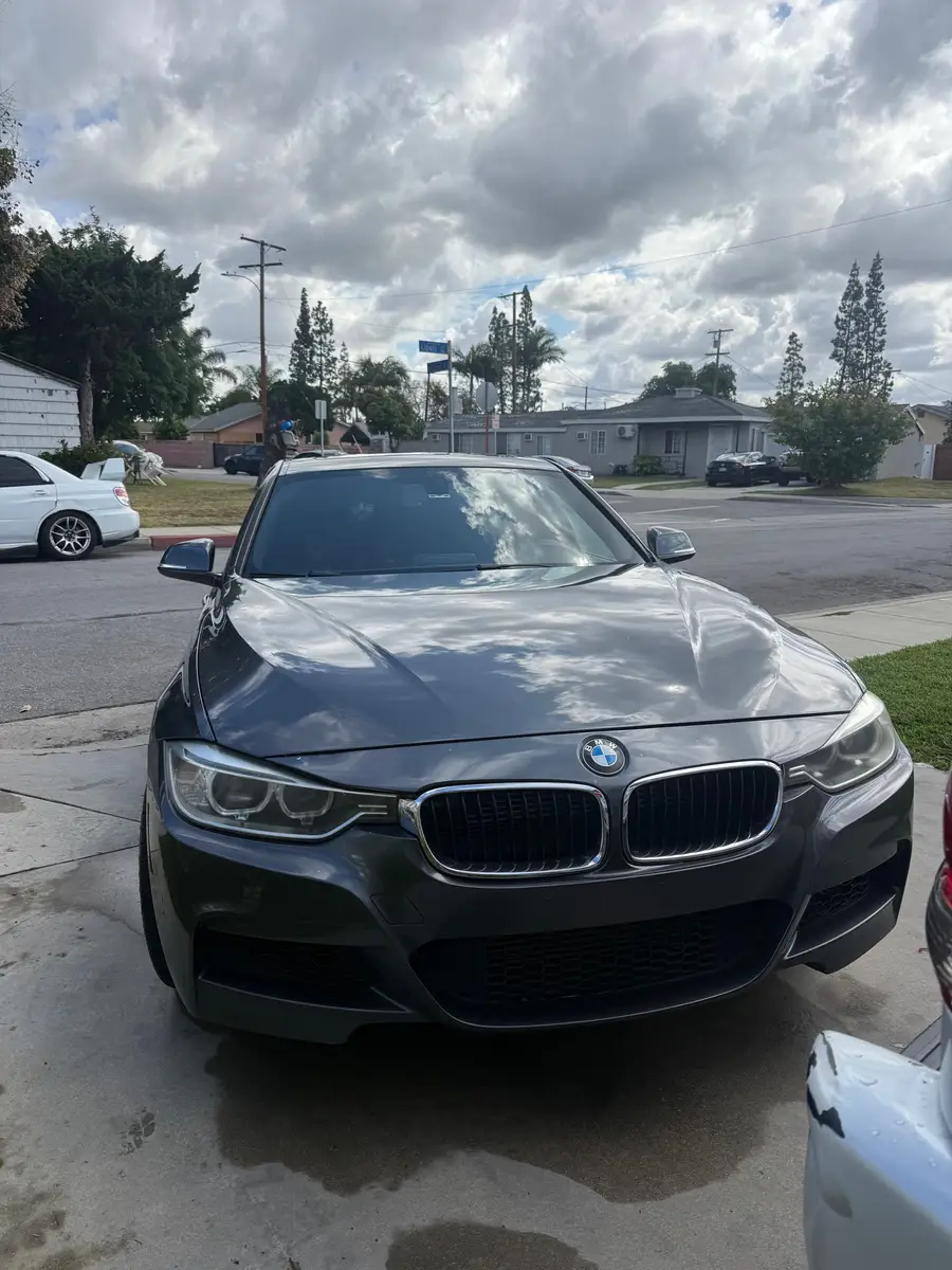 Dark grey BMW 3 Series after detailing, parked at the curb