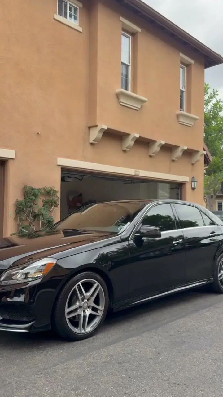 Black Mercedes-Benz E-Class beside a townhome garage after a detail