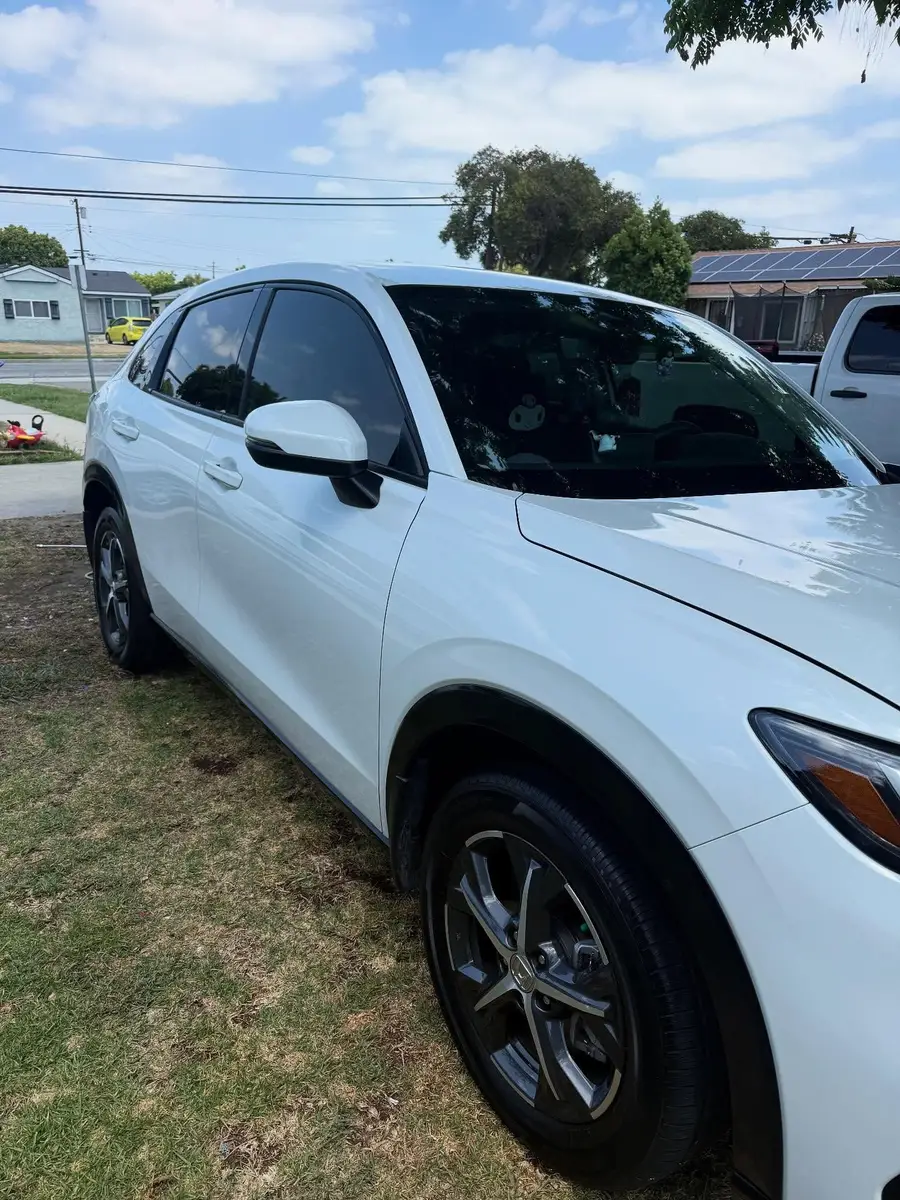 Side of a white Honda HR-V after a detail, parked on the lawn edge by the curb