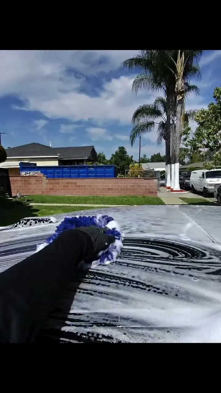 Wash mitt on a foamed black BMW i4 hood