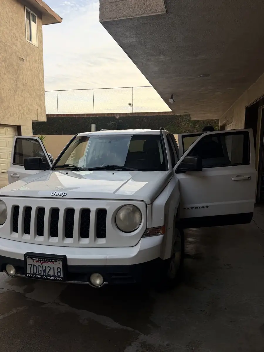 White Jeep Patriot after detailing, parked next to a building