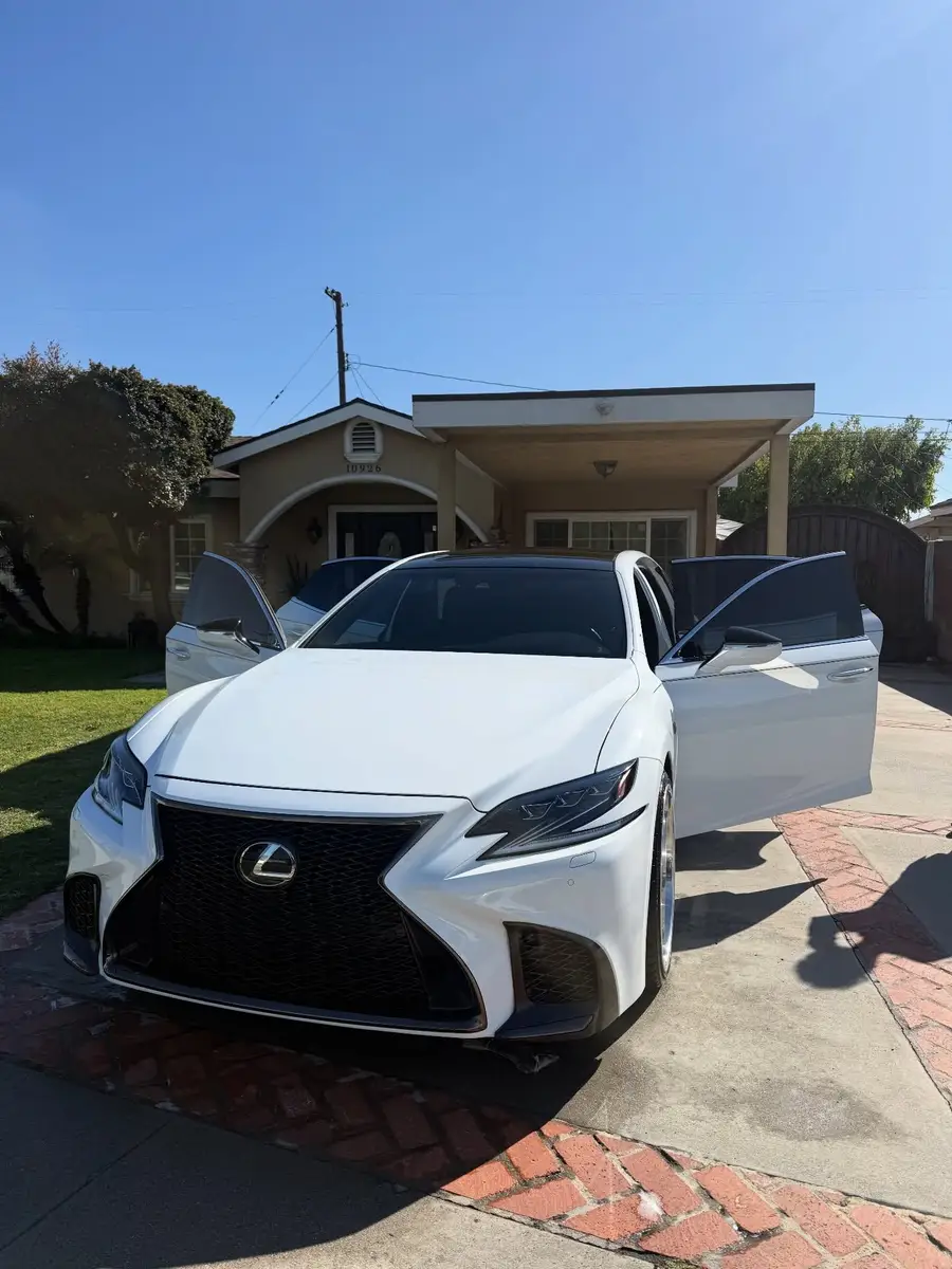 White Lexus LS 500 F Sport with the front doors open in a driveway