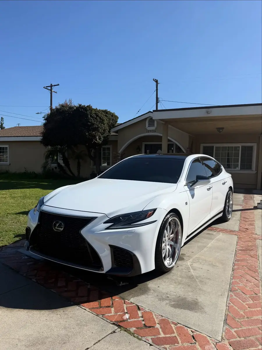 White Lexus LS 500 F Sport after detailing, in a driveway in front of a house