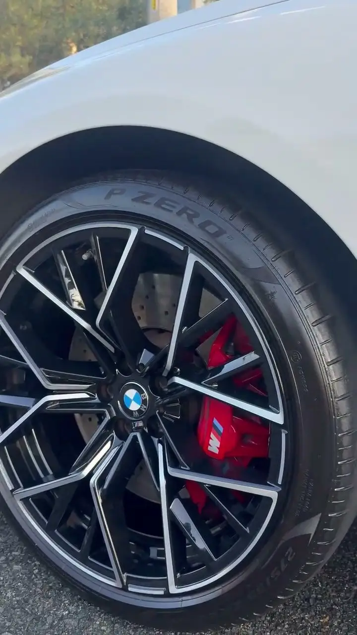 Cleaned BMW M8 wheel with red brake caliper and dressed tire
