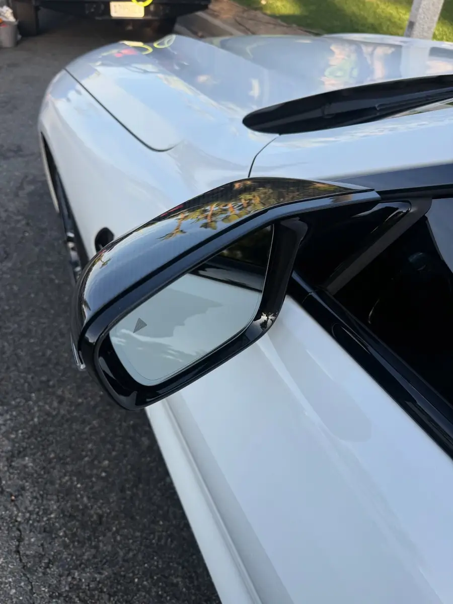 Side mirror of a white BMW after detailing