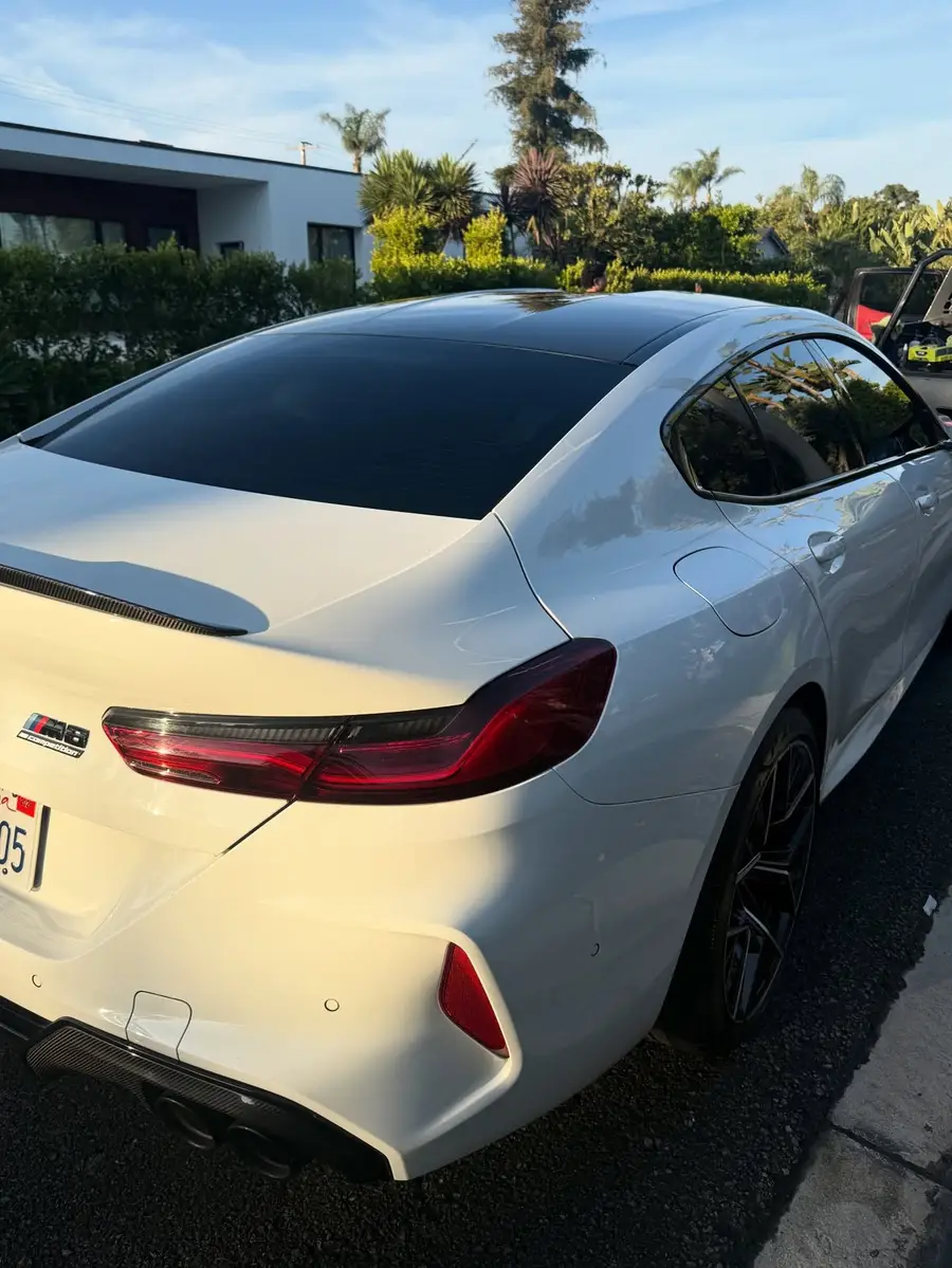 Rear quarter of a white BMW M8 after an exterior detail