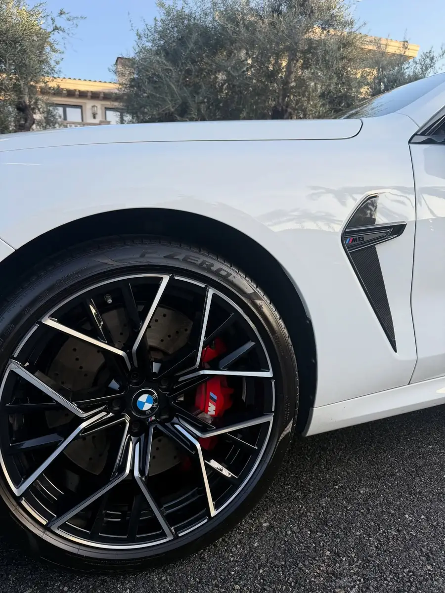 Close-up of a cleaned BMW M8 wheel, brake caliper and dressed tire