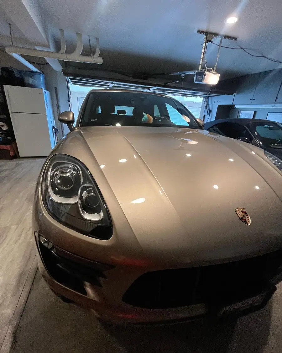 Champagne Porsche Macan on a maintenance detail inside a garage