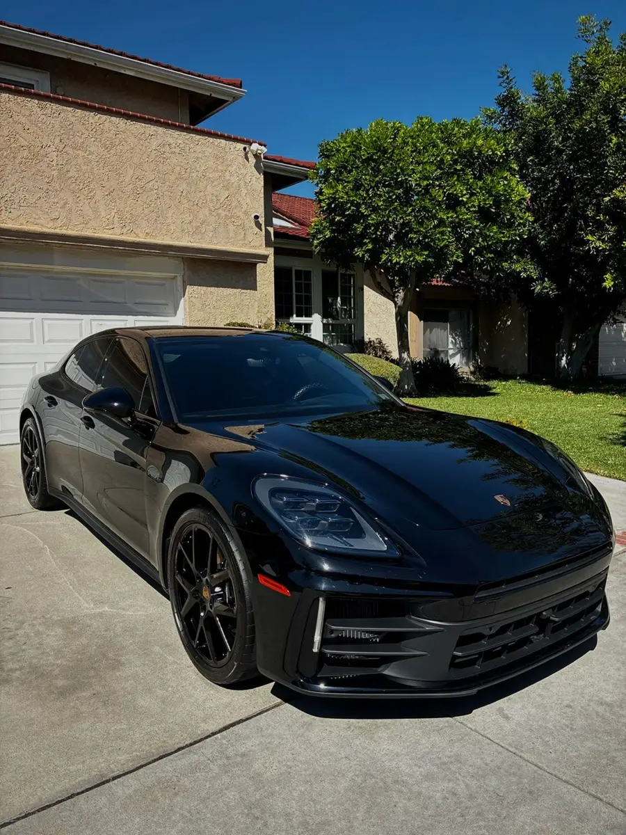 Black Porsche Panamera after a detail, parked in front of a house
