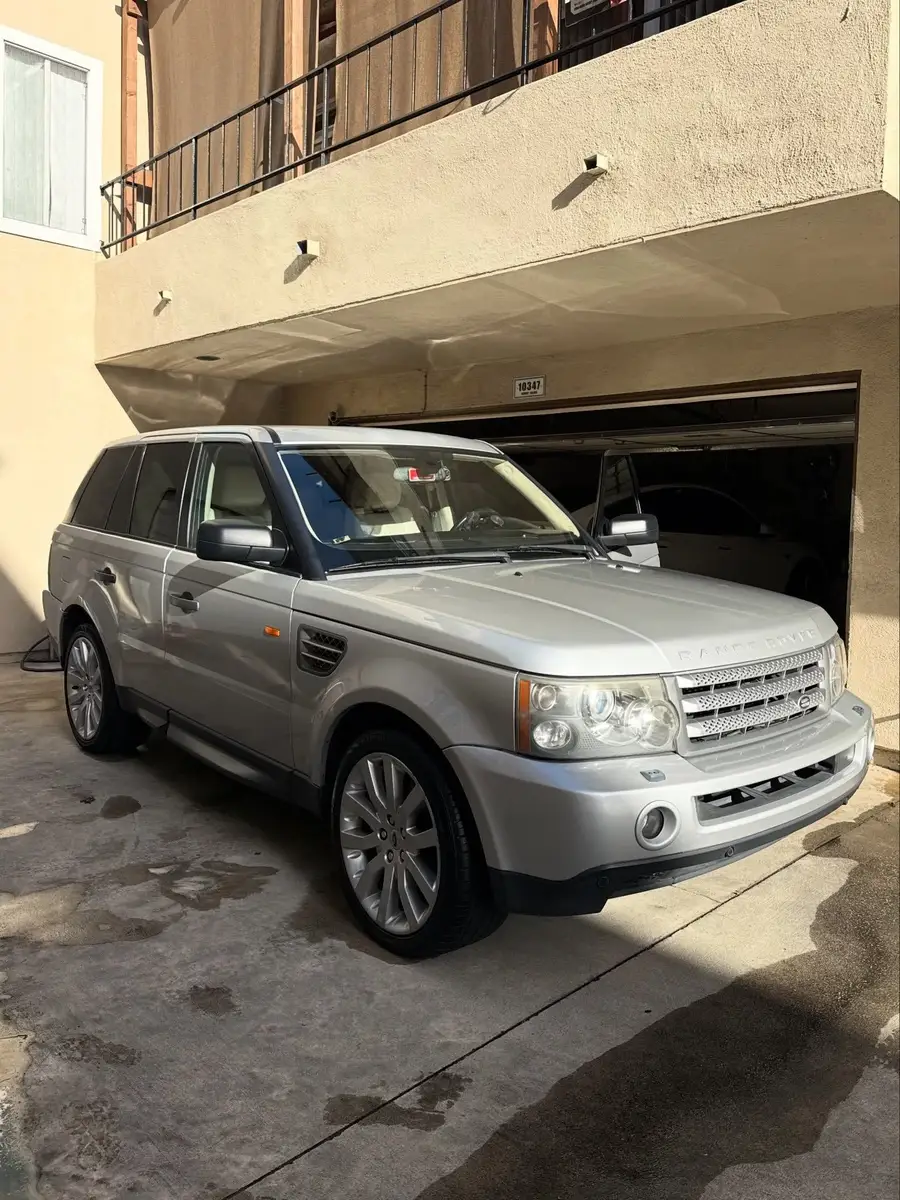 Silver Range Rover Sport after detailing, parked in front of a garage