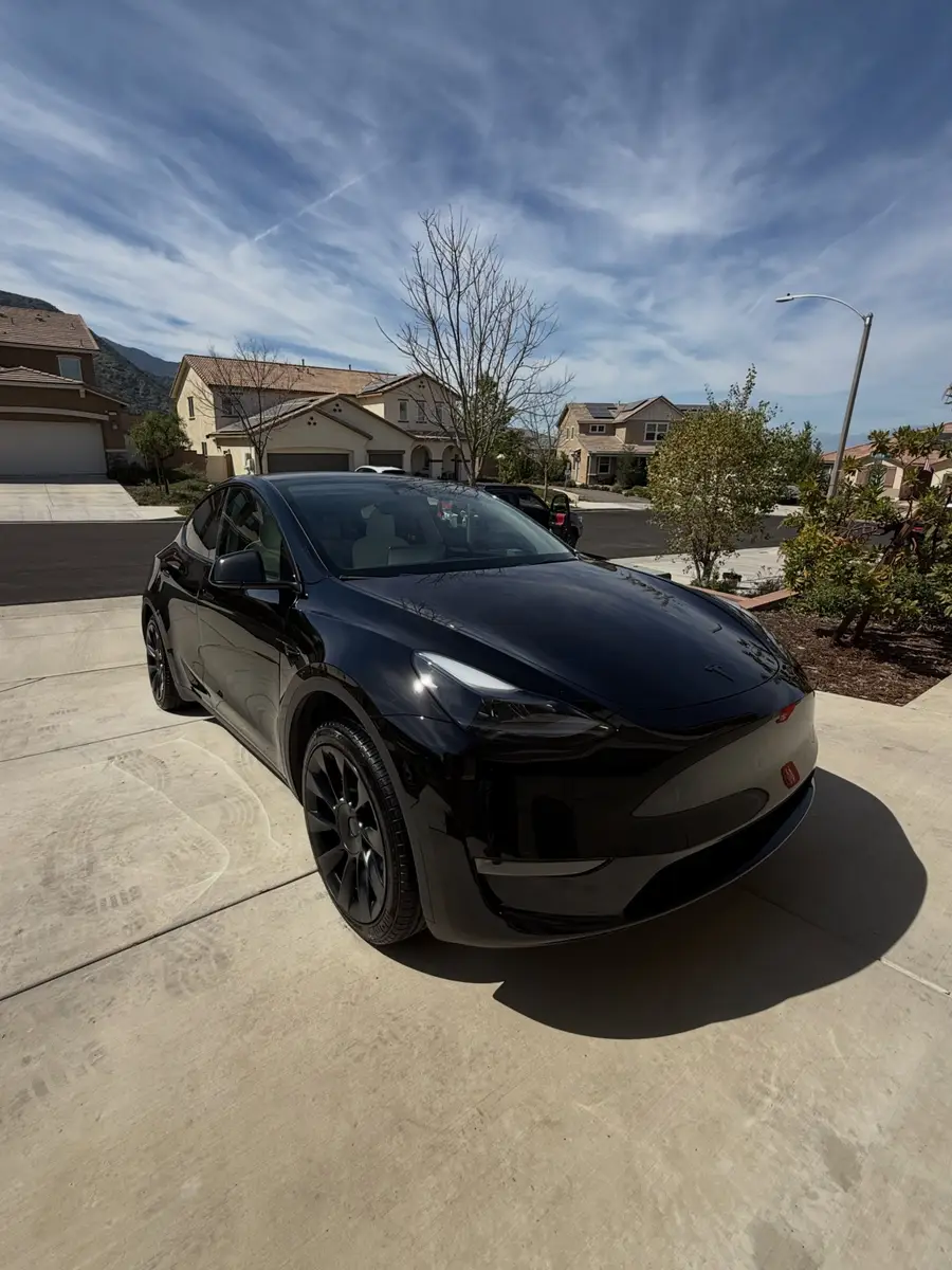 Black Tesla Model Y, washed and dried, in a customer driveway