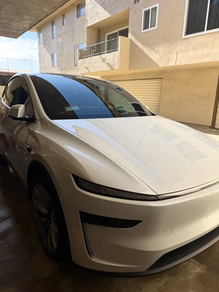 White Tesla Model Y after detailing, parked at a garage