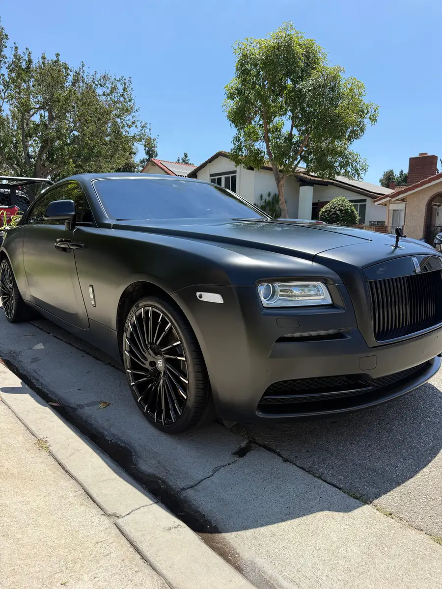 Matte black Rolls-Royce Wraith after detailing, parked at the curb