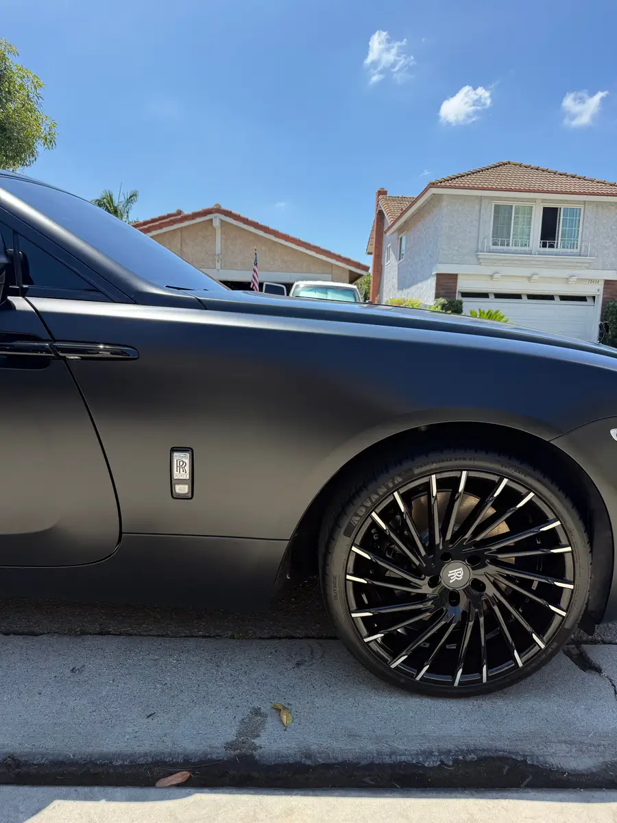 Cleaned wheel and dressed tire on a matte black Rolls-Royce Wraith